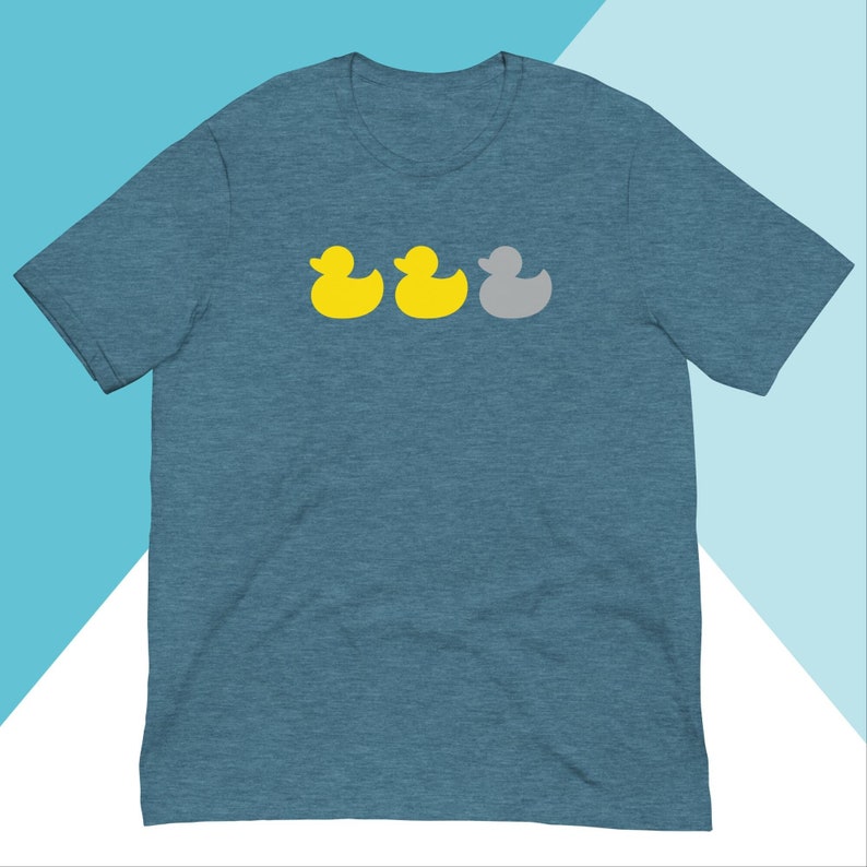 May include: A teal blue t-shirt featuring a graphic of three rubber ducks. Two of the ducks are yellow and one is grey.