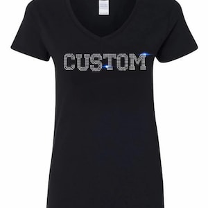 May include: Black V-neck t-shirt featuring the word "CUSTOM" in sparkling rhinestones. A classic style of top, ideal for customisation or personalisation. The design is centrally placed on the chest.