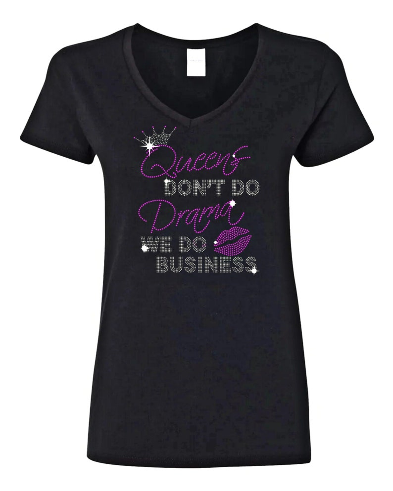 May include: Black v-neck t-shirt with a rhinestone design that says "Queens Don't Do Drama We Do Business" with a crown and a pink lip graphic.