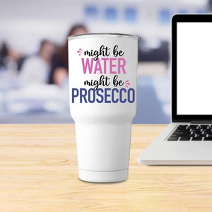 May include: White tumbler with a black and pink design that says "might be water might be prosecco".