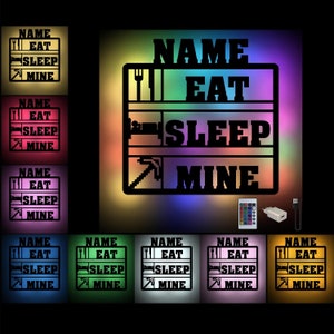 Könnte beinhalten: Ein schwarz-weißes Schild mit dem Text "NAME EAT SLEEP MINE" in einer Blockschrift. Das Schild wird mit einem mehrfarbigen LED-Licht beleuchtet. Das Schild ist in verschiedenen Farben erhältlich.