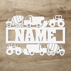 May include: White wooden cutout of a cement mixer, dump truck, tractor, and a name sign that says "NAME".