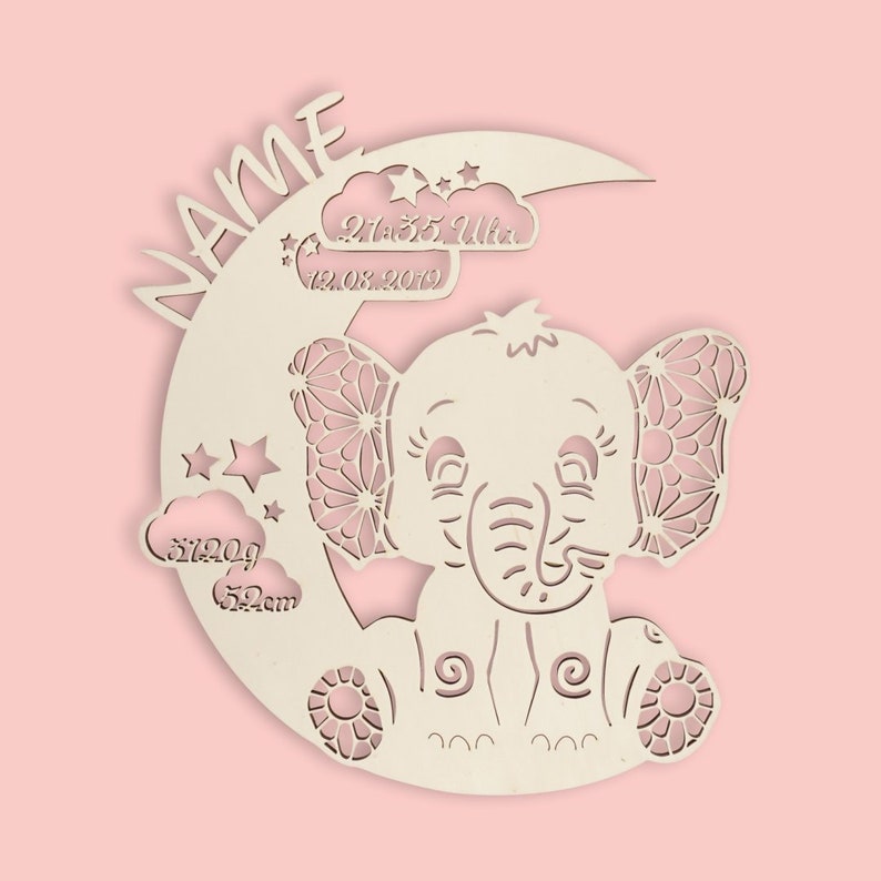 May include: A wooden cutout of an elephant sitting on a crescent moon. The elephant has detailed ears and a sweet expression. The moon has the text "NAME" and "21:35 Uhr 12.08.2019" on it. There are also clouds with the text "3120g 52cm" on them.