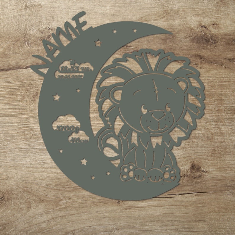 May include: A grey wooden cutout of a crescent moon with stars and clouds. A cute cartoon lion sits on the moon. The name "Jamie" is written on the top of the moon.