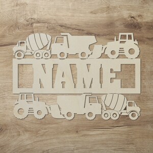 May include: White wooden cutout of a name sign with a cement mixer, dump truck, tractor and excavator. The sign says "NAME".