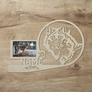 Könnte beinhalten: Holzbildrahmen mit einer Wolfssilhouette und einem Pfotenabdruck. Der Rahmen hat Platz für ein Foto und einen Platz für einen Namen. Der Text "NAME" ist auf dem Rahmen sichtbar.