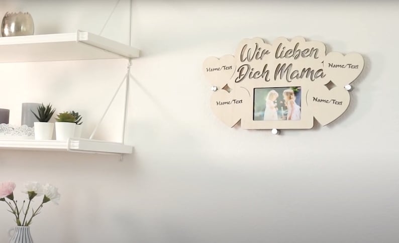 Puede incluir: Marco de fotos de madera con cinco recortes en forma de coraz&oacute;n. El marco tiene el texto "Wir lieben Dich Mama" y una foto de dos chicas. Cada recorte en forma de coraz&oacute;n tiene el texto "Name/Text" escrito en &eacute;l.