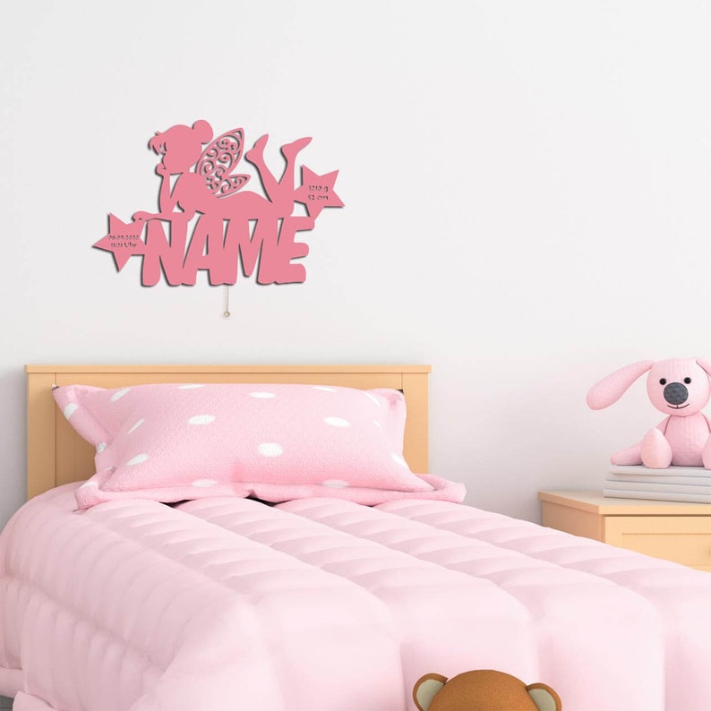 May include: Pink wooden fairy silhouette with a star and the word "NAME" on a white wall. The fairy is holding a star with the text "3.23.23 8:32 pm" on it.