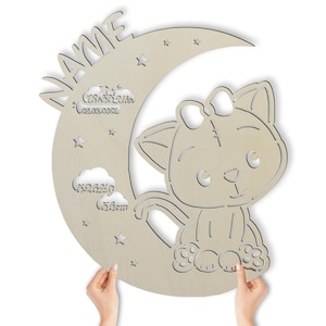 May include: A wooden cutout of a crescent moon with a cute cat sitting on it. The moon has stars and clouds with the text "NAME", "32.5oz", "20.04.2021", "5924.4g", and "56cm" on it.