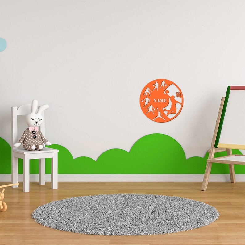 May include: Orange basketball themed wall decor with the word "NAME" in the center. The decor features silhouettes of basketball players in action.