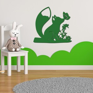 May include: Green wooden wall decor featuring a fox with a butterfly in its mouth. The fox is sitting on a small branch with leaves and flowers.