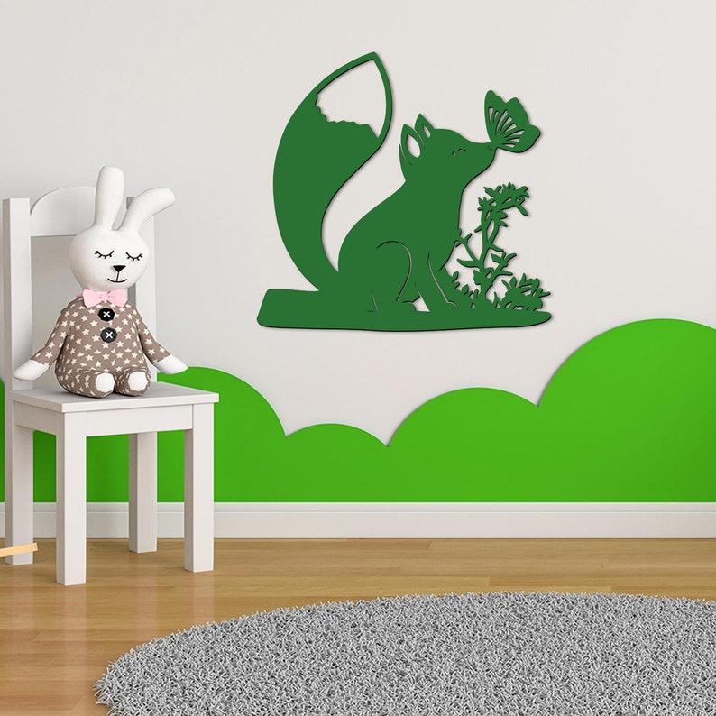 May include: Green wooden wall decor featuring a fox with a butterfly in its mouth. The fox is sitting on a small branch with leaves and flowers.