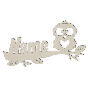 May include: Wooden owl with a heart on its chest, perched on a branch with the word "Name" and the date "22.07.2021 17:32 Uhr" and the number "3402 8". The branch is 50 cm long.