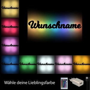 May include: A customizable LED light with a rainbow color gradient. The light features a cursive font with the text "Wunschname" and a remote control to change the color. The light is powered by a USB adapter.