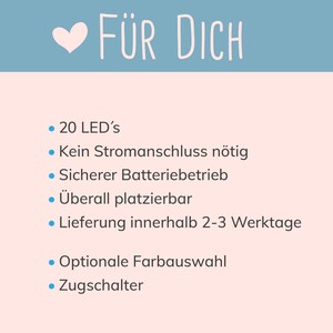 May include: A white background with blue text that reads "F&Uuml;R DICH".  A pink heart is to the left of the text.  Below the text is a list of features for a product, including 20 LEDs, battery operated, and optional color selection.