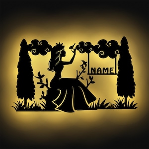 Könnte beinhalten: Eine schwarze Silhouette einer Frau mit einer Krone auf dem Kopf, die auf einem Felsen sitzt und einen Vogel in der Hand hält. Sie ist von Bäumen und Wolken umgeben. Der Text "NAME" befindet sich auf einer Schaukel im Hintergrund.
