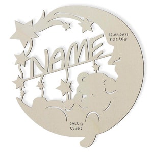 May include: A wooden cutout of a crescent moon with a sleeping bear inside. The moon has a shooting star and stars around it. The text "NAME" is above the bear and the date "22.06.2021 13:15 Uhr" is on the right side of the moon. The text "2955 A 53 cm" is at the bottom of the moon.