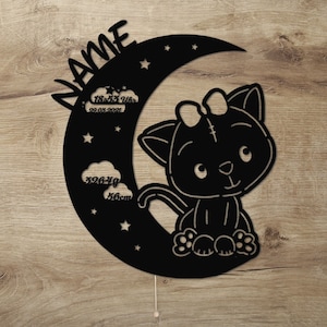 May include: Black silhouette of a cat with a bow sitting on a crescent moon with stars. The moon also has text that reads "NAME", "18:53 Uhr", "29.03.2021", "3926g", and "56cm".