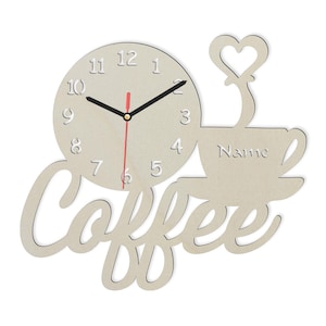 Op de afbeelding: Een houten koffiemok-klok met het woord "Coffee" in een gestileerd lettertype. De wijzerplaat van de klok heeft zwarte wijzers en een rode secondewijzer. De mok heeft een hartvormig handvat en het woord "Name" staat op de zijkant.