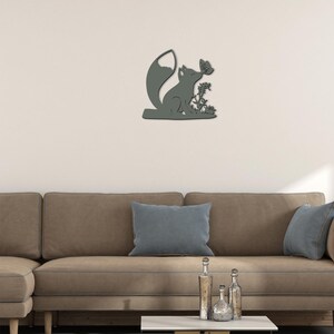 May include: A gray wooden wall decor featuring a silhouette of a fox with a butterfly on its nose. The fox is sitting on a branch with leaves and flowers.