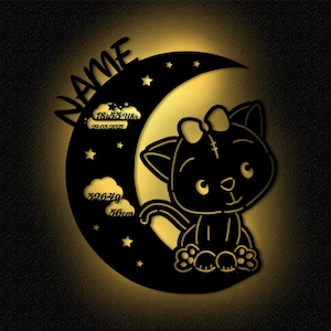 May include: Black silhouette of a cat with a bow sitting on a crescent moon with stars. The moon has text that reads "NAME", "18:55 Uhr", "22.03.2021", "3264g", and "56cm".