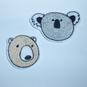 Könnte beinhalten: Zwei gestickte Aufnäher mit Tiergesichtern. Einer ist ein Bär mit beigem Körper, weißer Schnauze und schwarzen Details. Der andere ist ein Koala mit grauem Körper und schwarzen Details. Beide Aufnäher haben einen weißen Rand.