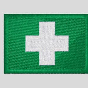 Könnte beinhalten: Gestickter grüner Aufnäher mit einem weißen Kreuz, einem universellen Symbol für Erste Hilfe. Das Kreuz befindet sich mittig auf einem grünen rechteckigen Hintergrund. Der Aufnäher ist für eine Uniform oder eine Tasche bestimmt.