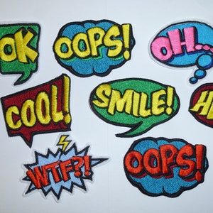 Könnte beinhalten: Eine Sammlung von aufgestickten Aufnähern in verschiedenen Sprechblasenformen. Jeder Aufnäher zeigt ein anderes Wort oder eine andere Phrase in fetter, farbiger Schrift, darunter "OK", "OOPS", "OH", "COOL", "SMILE", "HEY", "WTF?!" und nochmals "OOPS!"