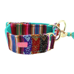 Puede incluir: Un collar para perros colorido con un diseño de tela tejida en tonos rojos, morados y marrones. El collar tiene un forro turquesa y un cierre de metal dorado. Una borla turquesa cuelga del lateral. El collar tiene una etiqueta rosa con texto.