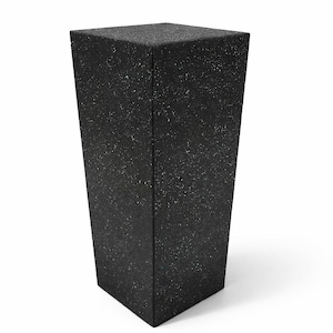 Könnte beinhalten: Ein hoher, quadratischer Sockel mit verjüngter Basis, der eine dunkel-schwarze Oberfläche mit einer feinen, weiß gesprenkelten Textur aufweist. Das Objekt steht aufrecht mit einer flachen Oberseite und vier vertikalen Seitenkanten.