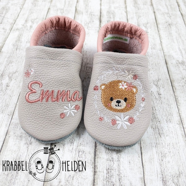 Baby shoes in light gray leather slippers with a bear in a wreath of flowers and an embroidered name made of real leather
