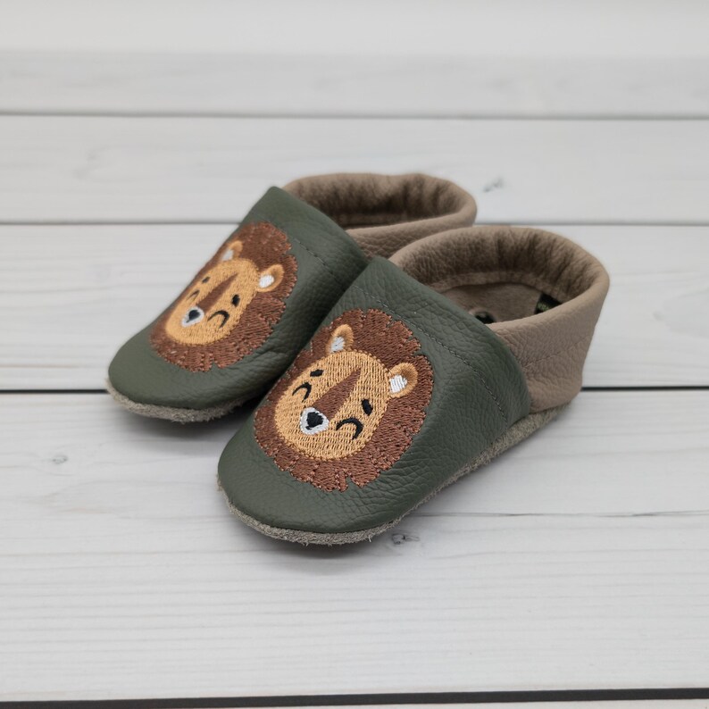 Krabbelschuhe in olivgrün, grün und brauch mit Löwe und Name bestickt. www.krabbelhelden.de
