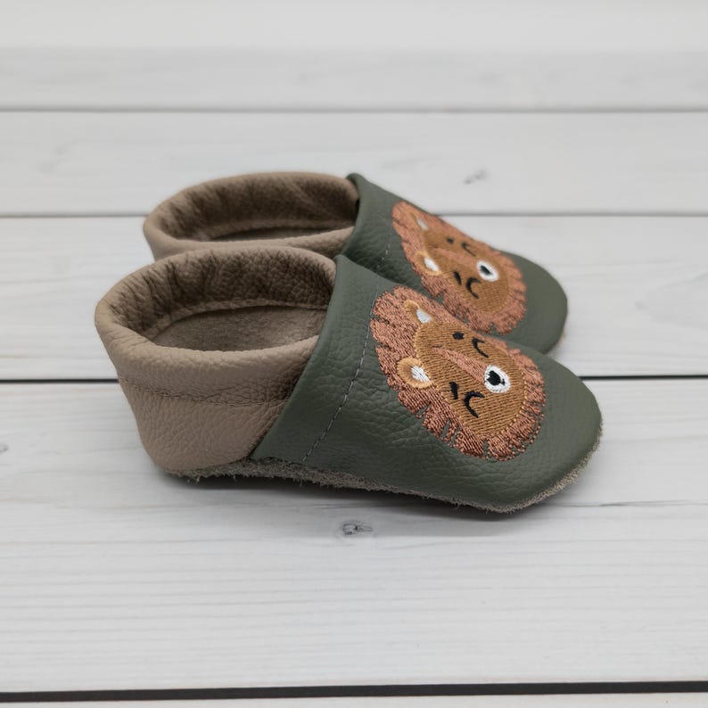 Krabbelschuhe in olivgrün, grün und brauch mit Löwe und Name bestickt. www.krabbelhelden.de
