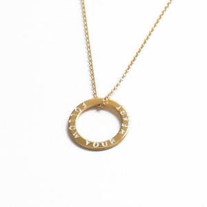 May include: Gold necklace with a circular pendant that reads "Follow Your Heart".