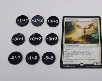 Può includere: Una carta di Magic: The Gathering in bianco e nero con Sunblast Angel, una creatura con la capacità di volare. Il testo della carta recita "Quando Sunblast Angel entra in gioco, distruggi tutte le creature che sono tappate." La carta è circondata da gettoni di plastica neri con numeri bianchi, che rappresentano +1/+1, +2/+2, +3/+3, +0/+1, +0/+2, +0/+3, -0/-1, -1/-0, -5/-5, +1/+0, +1/+2, +4/+4, +2/+0, +2/+1, +5/+5, +3/+0, +3/+1, +3/+2.