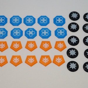 May include: A set of 30 game pieces, including 10 blue, 10 orange, and 10 black tokens. The blue tokens have a white flower design, the orange tokens have a white star design, and the black tokens have a white star design.