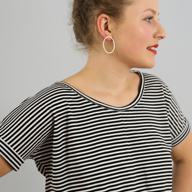 May include: A black and white striped t-shirt with a scoop neck and short sleeves. The shirt is made of a soft, comfortable fabric.