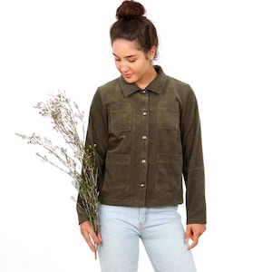 Könnte beinhalten: Eine olivgrüne Cordjacke mit klassischem Kragen, langen Ärmeln und einer durchgehenden Knopfleiste. Das Kleidungsstück verfügt über zwei Brusttaschen und zwei untere Taschen, jeweils mit rechteckigen Klappen. Dazu wird eine hellblaue Jeans getragen.