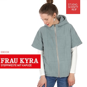 Op de afbeelding: Lichtblauwe gewatteerde jas met capuchon en een ritssluiting over de hele lengte. De jas heeft korte mouwen en wordt over een wit shirt met lange mouwen gedragen. De tekst "FRAU KYRA STEPPWESTE MIT KAPUZE" staat in het rood.