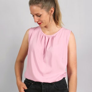 Op de afbeelding: Een roze top zonder mouwen met een geplooide halslijn. De top is gemaakt van een zachte, lichte stof.