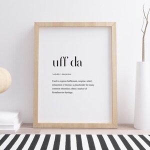 May include: A black and white printable wall art print with the word "uff da" and its definition. The definition explains that "uff da" is an interjection used to express bafflement, surprise, relief, exhaustion or dismay. It is often used as a placeholder for many common obscenities and is a marker of Scandinavian heritage.