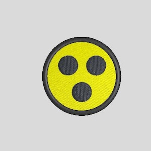 May include: A yellow circle with a black outline and three black circles inside, resembling a face with eyes and a mouth.