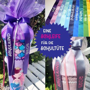 Peut inclure: Un cornet d'école violet avec un motif de sirène, noué avec un ruban et du tulle violets. Le ruban porte les inscriptions "SCHULKIND" et "2025". Une palette de couleurs de rubans est affichée, dont le rouge, le jaune, le vert et le bleu.