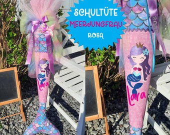 May include: A pink and purple mermaid-themed school bag with a mermaid illustration and the text "Schultüte Meerjungfrau Rosa".
