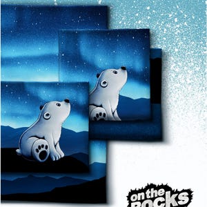 Könnte beinhalten: Ein Set aus quadratischen Leinwänden mit einem weißen Eisbärenbaby, das auf einem dunklen Felsen vor einem blauen Nachthimmel mit Sternen und Nordlichtern sitzt. Der Text "on the rocks BY THORSTEN BERGER" steht unten rechts im Bild.