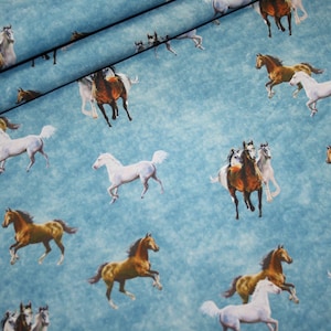 Op de afbeelding: Stof met een herhalend patroon van paarden in verschillende kleuren, waaronder bruin, wit en beige, tegen een lichtblauwe achtergrond. De paarden worden in beweging afgebeeld, wat een dynamisch en levendig ontwerp creëert. Deze stof is geschikt voor diverse knutselprojecten.