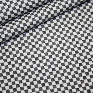 Può includere: Primo piano di un tessuto con un motivo a scacchi bianchi e neri. Il tessuto è piegato, mostrando la trama e il design. Il motivo è composto da piccoli quadrati distanziati uniformemente, creando un look classico e versatile.