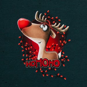 Könnte beinhalten: Ein dunkelgrüner Stoff mit einem Cartoon-Rentier mit großer roter Nase und Geweih, umgeben von einer Lichterkette mit roten Weihnachtslichtern. Unter dem Rentier ist der Text HOHOHO in fetten roten Buchstaben mit schwarzem Rand gedruckt.