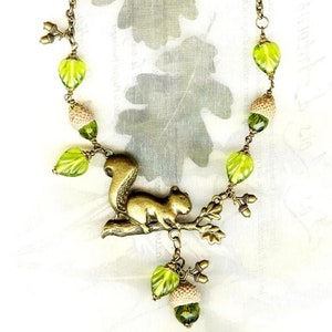 Collier ECUREUIL des CHÊNES bronze avec coupelles naturelles de GLANDS perles en cristal et feuilles en verre olivine Active image 2