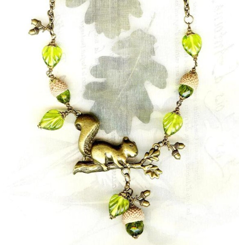 Collier ECUREUIL des CHÊNES bronze avec coupelles naturelles de GLANDS perles en cristal et feuilles en verre olivine Active image 2